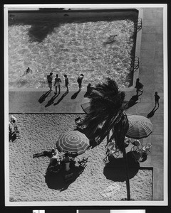 View looking down upon people tanning and swimming in a pool in Coronado, ca.1950