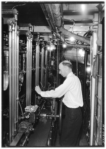 Close-up of a man working controls in the interior of a ship, May 1, 1936