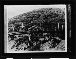 Mount Lowe railway car on circular bridge, showing car from the side, 1895