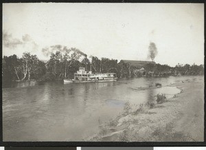 Steamboat on a river in front of a door factory, Red Bluff, 1900-1940