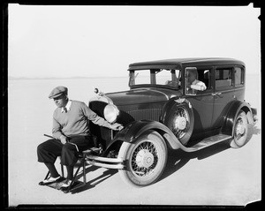 Golfer seated on the front bumper of an automobile