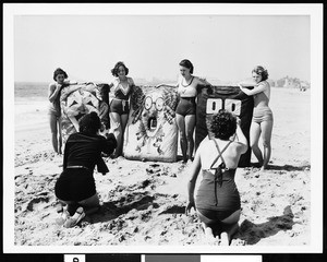 Women throwing balls at targets on the beach