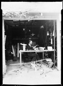 Man making model airplanes in his garage in Pasadena