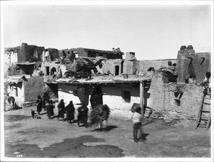 Hopi Indian men returning to their adobe dwellings in the village of Shonguapavi, ca.1900