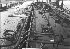 Liquid being exchanged between a ship and a wharf, ca.1920