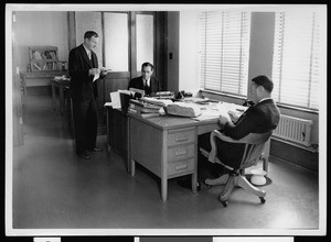 Three men working in Mr. Cartelyan's office at the Department of Public Works