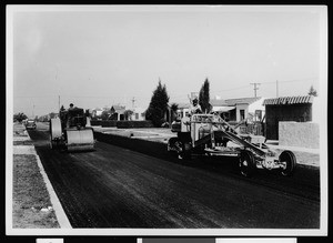 Two machines paving a residential street in Los Angeles