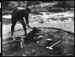 A man demonstrating how to put out a campfire near Lolo National Forest, Montana, ca.1930