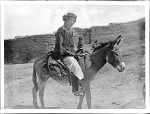 A Zuni Indian man riding donkey to his cornfied, ca.1898