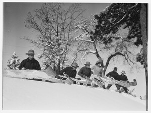 Seven people about to toboggan down a hill at Big Pines