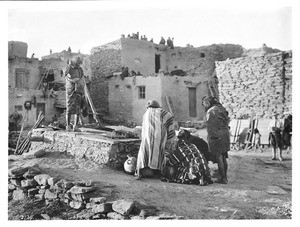 Hopi Indian snake priest standing on the snake kiva about to retrieve the emetic during the Hopi Snake Dance Ceremony, Oraibi, Arizona, ca.1898