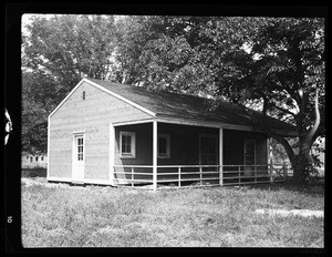 An exterior view of a one-bedroom house, showing a porch patio at the entrance