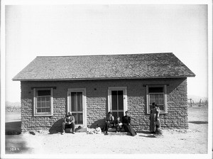 Group of people in front of an modern Pima Indian adobe house, ca.1900