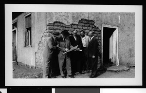 Group of men examining plans outside an adobe house in Ocean Park, ca.1950
