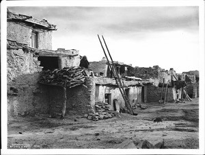 Hopi Indian on top of adobe dwellings in the village of Shonguapavi, ca.1901