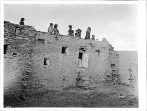 Hopi Indian children playing on top of an adobe dwelling, ca.1900