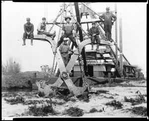 View of six men posing on the number three dredge on the Kings River, 1909