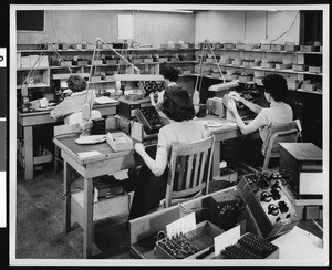 Group of women workers for Ircal Industries adjusting knobs on panels, ca.1940