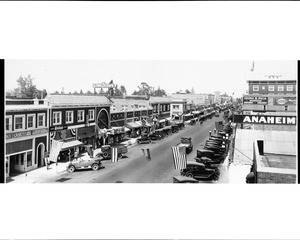 Birdseye view of a street in Anaheim decorated with American flags, ca.1925