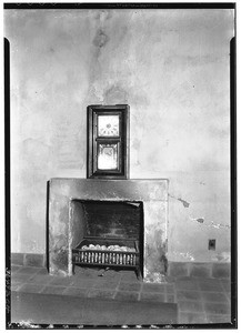 View of a fireplace with a clock on its mantel