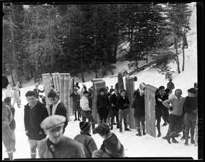 Large group of people lining up with toboggans in hand at Big Pines Camp