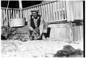 Man crouching by a porch