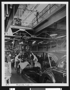 Interior view of a Los Angeles automobile factory showing workers on an assembly line, ca.1925