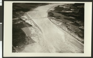 Aerial view of flooding of the Santa Ana River, showing flooding over roads and crops, ca.1930