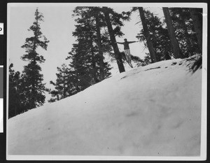 Ski jumper leaping from a snowy hillside, ca.1930