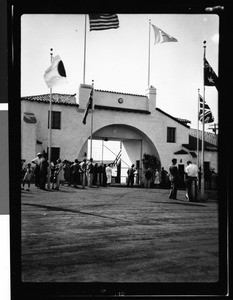 Main entrance of the Olympic Village, showing people standing outside, 1932