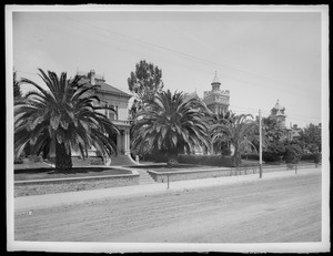 Exterior view of thee mansions lining Figueroa Street near Orange Street and Sixth Street, ca.1898