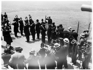 Naval officers saluting on the deck of a battleship