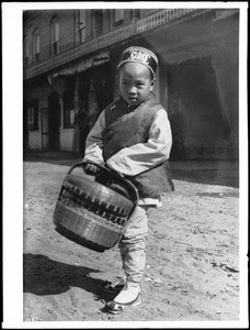 Small Chinese boy carrying a basket