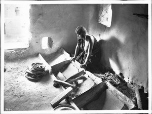 Young Hopi Indian woman grinding corn for flour, ca.1900