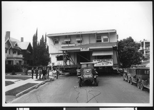 House being moved by truck, ca.1925