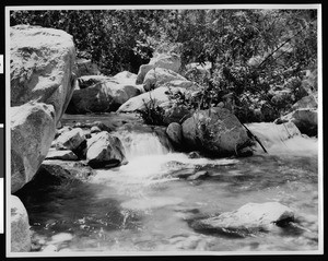 Water flowing over rocks in Andreas Canyon in Palm Springs, ca.1900