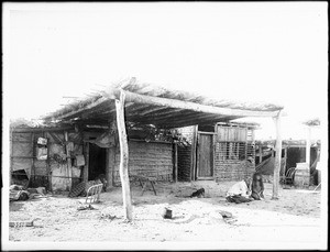 Two women and a child in front of a Yuma Indian dwelling, ca.1900