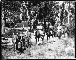 Group of men and women on horseback, accompanied by Professor George Wharton James, in Sierra Madre forest