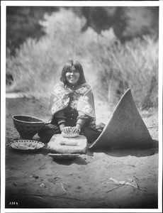 Havasupai Indian woman grinding corn into meal, ca.1900