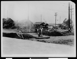 Department of Public Works workers digging next to railroad tracks, ca.1900