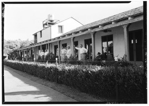 Men standing on the porch of the clubhouse at the Sunset Golf Club in Baldwin Hills