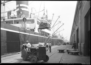 Stevedores unloading pallets from a cargo ship in Los Angeles Harbor