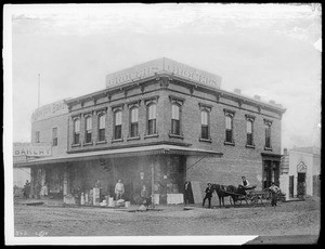 Exterior view of Ralphs Brothers Grocery and New York Bakery, located on the southwest corner of Sixth Street and Spring Street, 1886