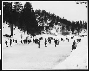 People skating on an outdoor ice rink at Big Pines mountain camp, ca.1930