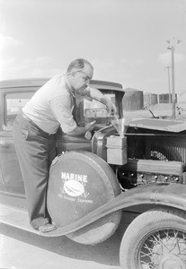 Man pouring gasoline into an automobile