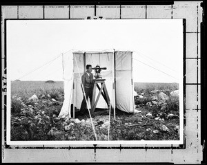 Department of Public works surveyor looking through an instrument, 1930-1939