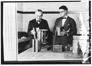 Portrait of Dr. Millikan and Dr. Cameron applying the lead sheild to an early form of electroscope, December 1930