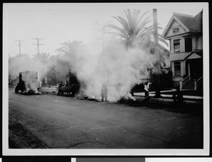 Workers spreading asphalt on an unidentified street