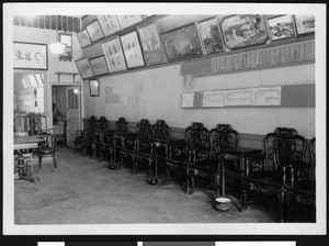 Interior view of a large room with ornate Chinese chairs along the wall, ca.1920-1929