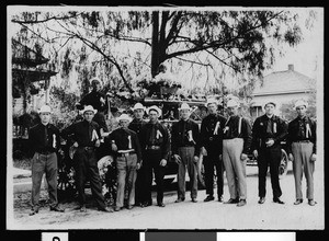 Portrait of members of the Monrovia fire department standing in front of the local fire engine, 1909